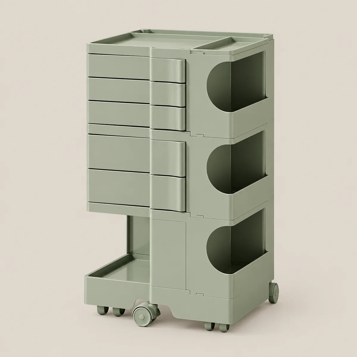A modern rolling storage cart in a muted sage green color, featuring five drawers on the left, three open storage compartments with circular cutouts on the right, and a lower pull-out tray on casters, set against a solid light beige background.