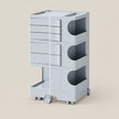 A light gray rolling storage cart with five drawers on the left, three open side compartments with semicircular cutouts on the right, and a lower pull-out tray, shown on a plain beige background.