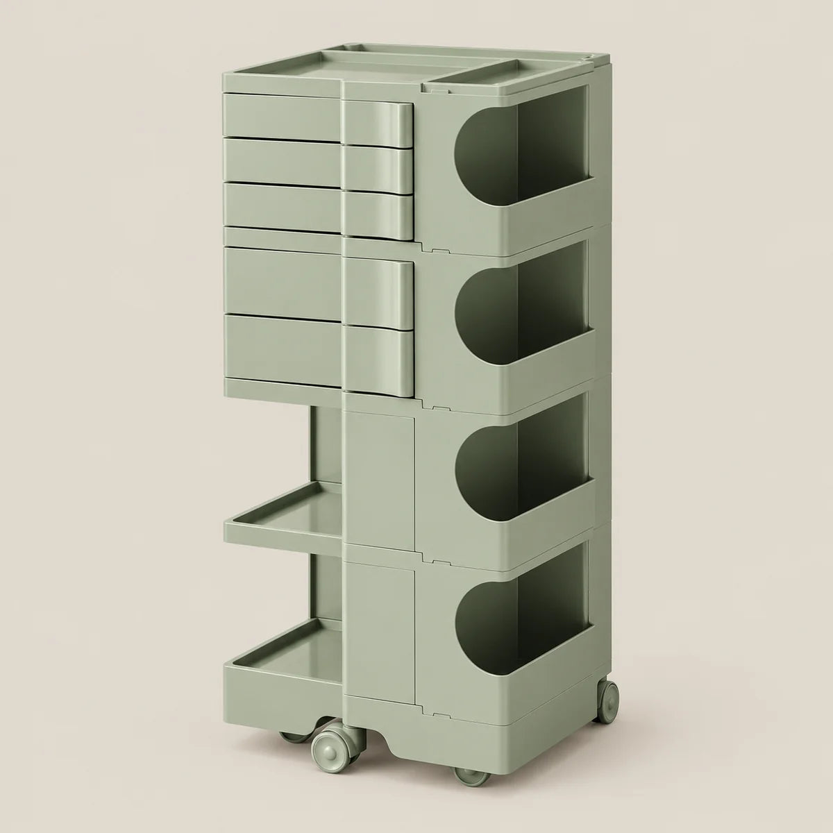 A tall, modular storage cart in a muted sage green color, featuring multiple drawers, open shelves, and wheels, set against a solid light beige background.