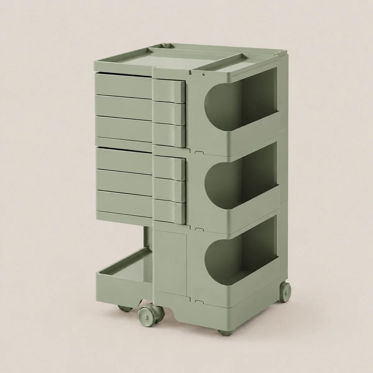 A sage green rolling storage cart with multiple drawers and open shelves, shown on a plain warm beige studio background.