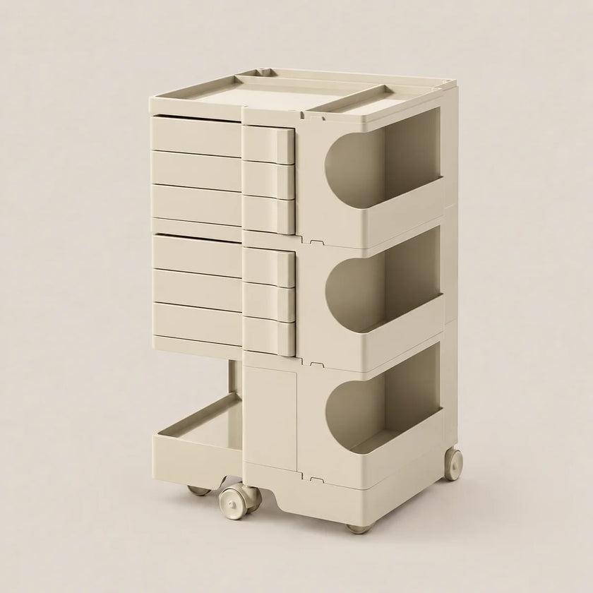 A cream-colored modular storage cart with multiple drawers and open shelves, shown on a clean, solid, warm beige background.