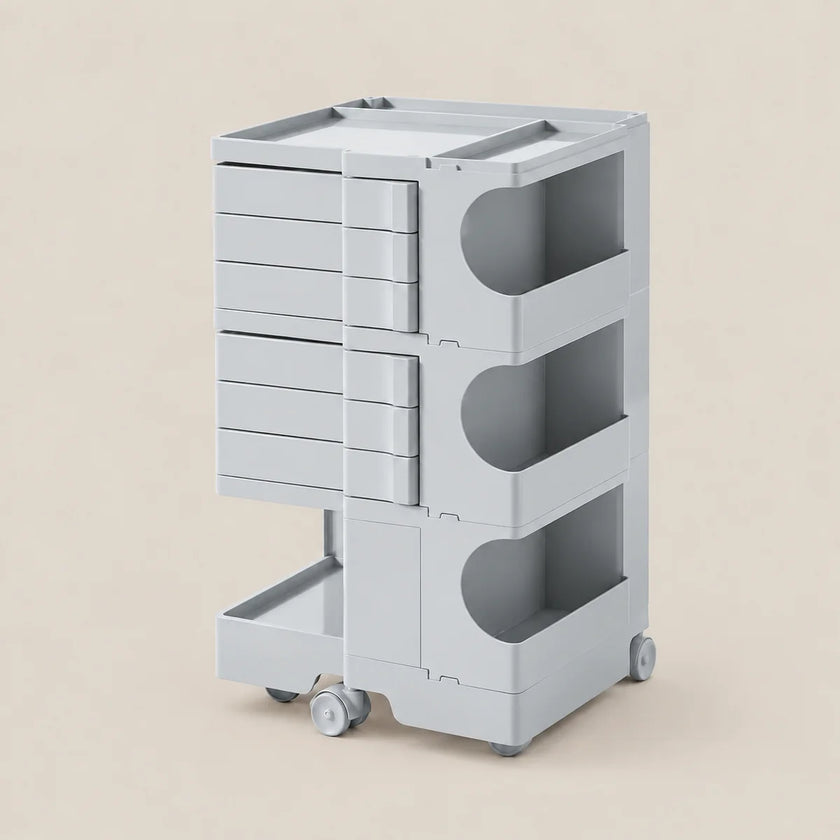 A light gray plastic rolling storage cart with three tiers of drawers on the left, open curved shelves on the right, and casters at the base, shown on a solid beige background.