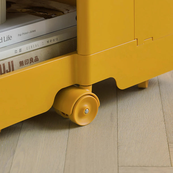 Yellow storage unit with books on a wooden floor