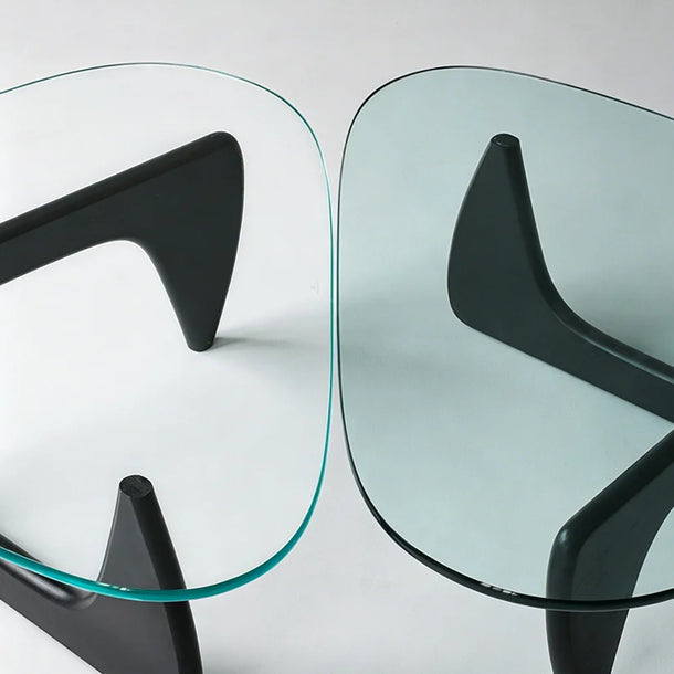 Two modern glass tables with black metal legs on a white background
