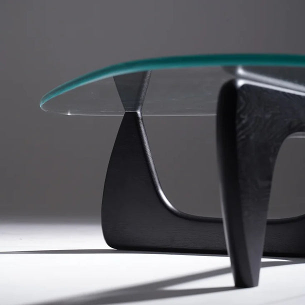 Modern glass coffee table with black base on a gray background