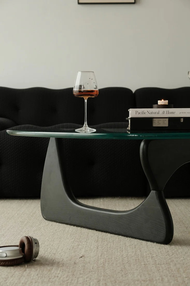 Modern glass coffee table with a wine glass on a living room setting