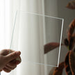 Clear square sheet held by a hand with a blurred background