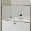 Glass display case with metal frame on a neutral background