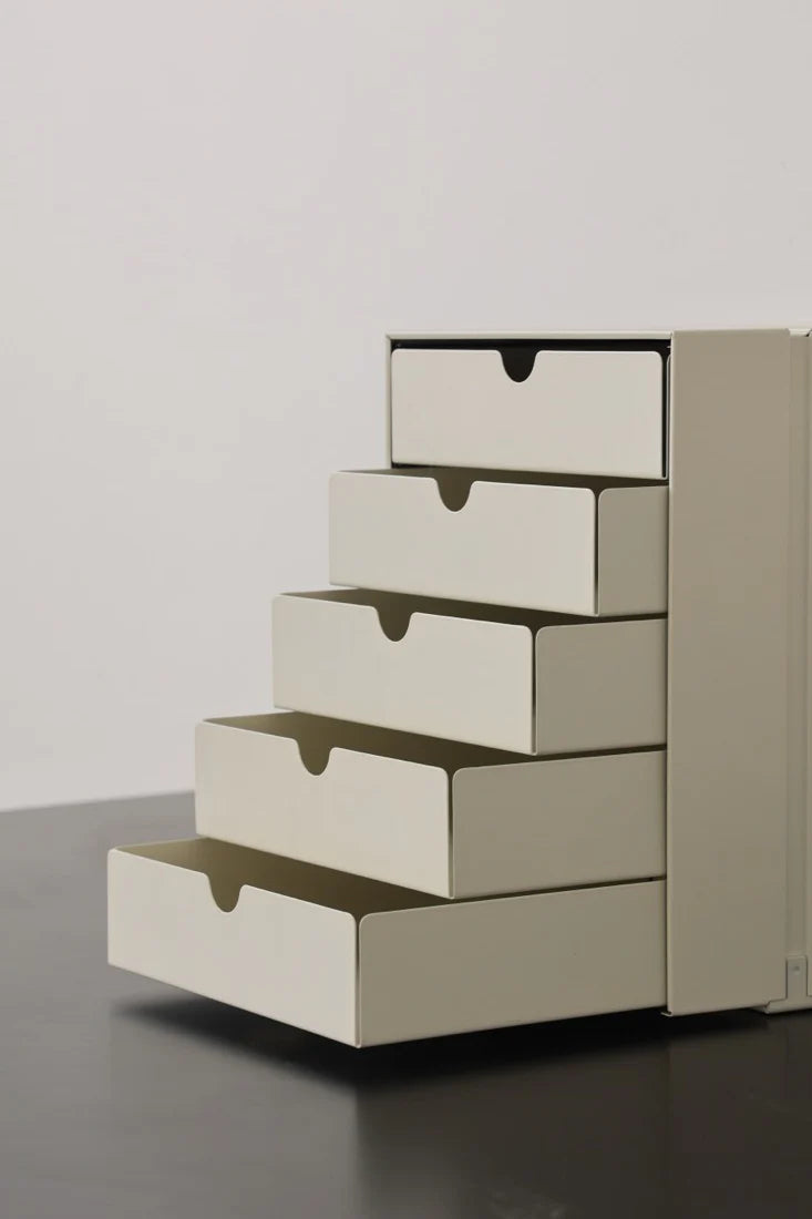 Stack of beige drawers on a gray surface with a light gray background