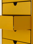 Close-up of a yellow metal cabinet with multiple drawers.