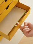Hand opening a yellow box with a green interior