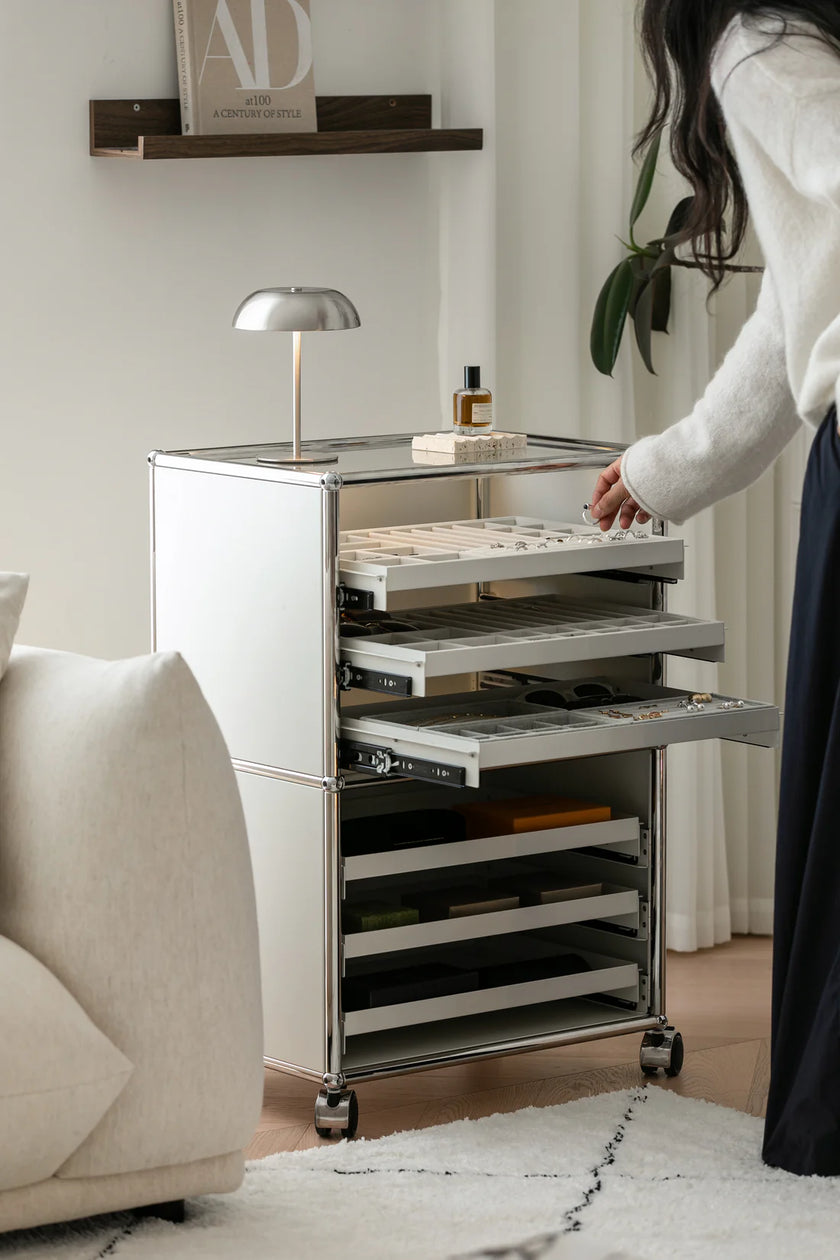 Person interacting with a modern rolling cart in a living room setting.