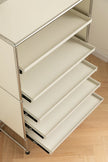 White metal shelving unit with multiple shelves on a wooden floor.