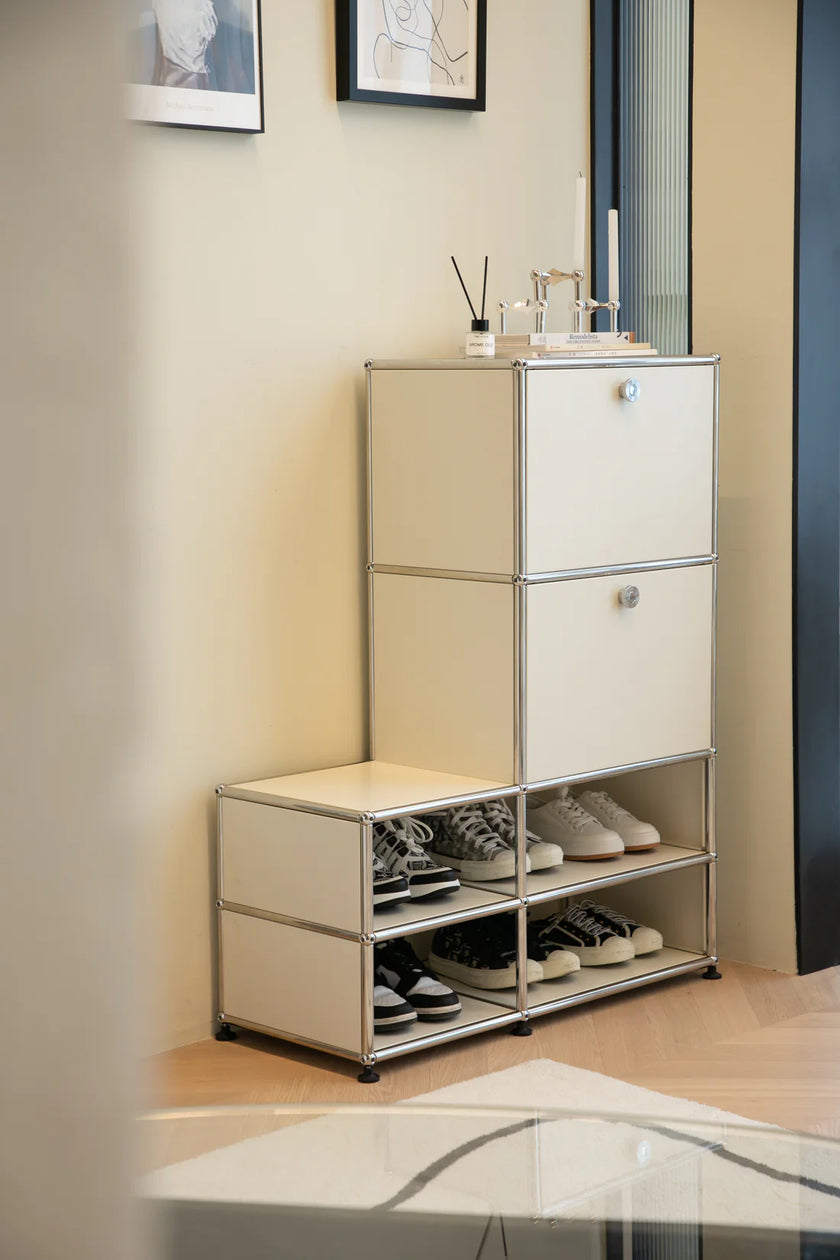 White shoe cabinet with open door showing shoes inside, placed against a wall.