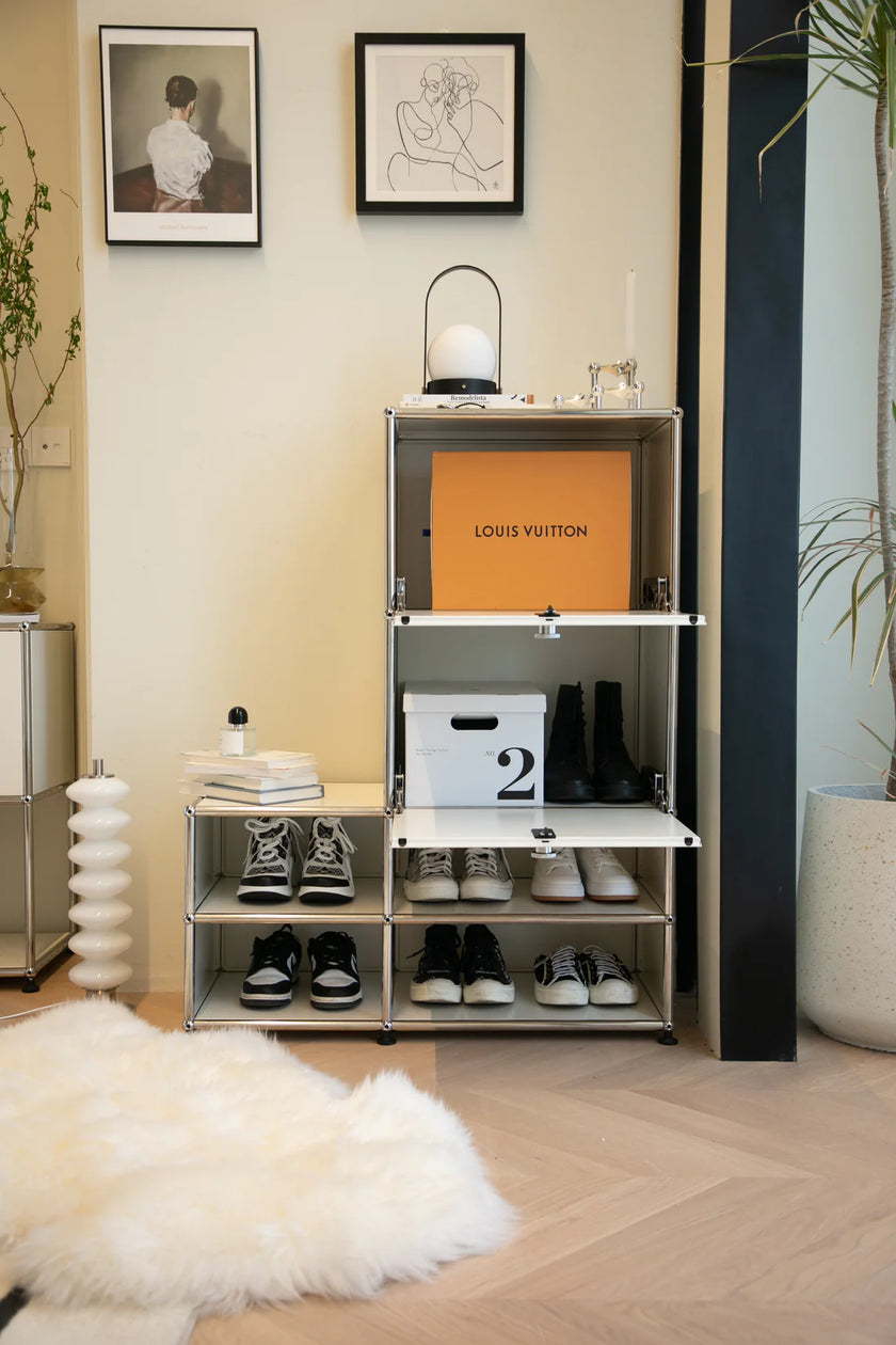 Shelving unit with shoes and a Louis Vuitton box in a room with decor elements.