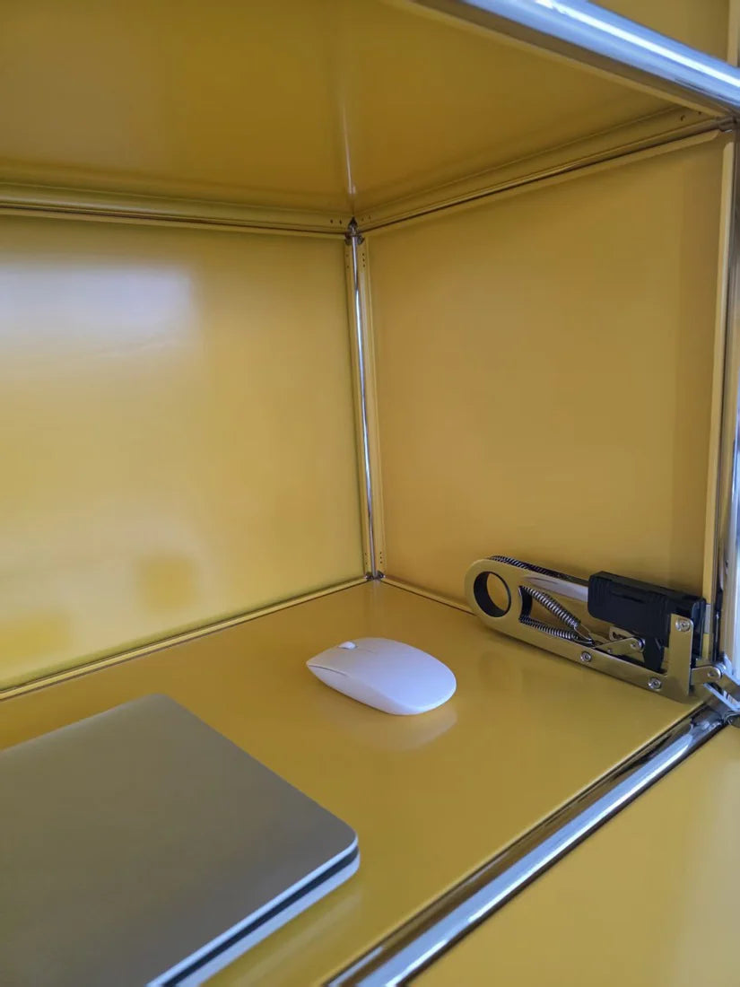 Yellow desk with a laptop, mouse, and stapler on top