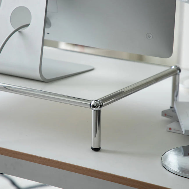 Metal stand with a computer monitor on a white surface