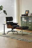 Black leather lounge chair with ottoman in a room with green filing cabinets and a plant.
