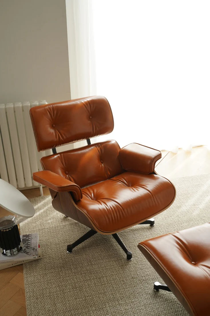 Brown leather armchair and ottoman in a room with a radiator and window.