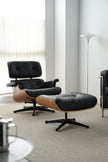 Modern black lounge chair with ottoman in a minimalistic room.