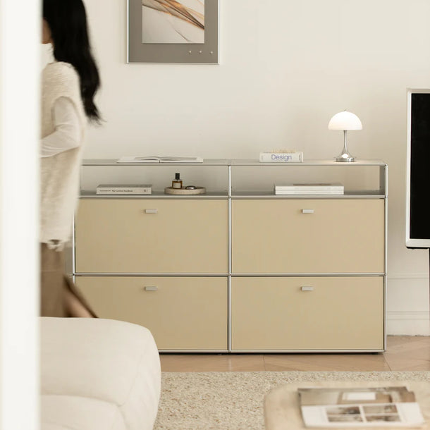 Beige storage unit in a room with a woman standing by a window.