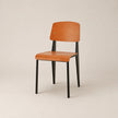 Wooden chair with black legs on a beige background