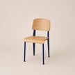 Chair with wooden seat and backrest and blue metal legs on a beige background