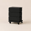 Black three-drawer rolling cart on a beige background
