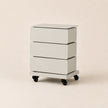 White three-drawer rolling cart on a beige background
