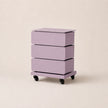 Purple rolling storage cart with three drawers on a beige background