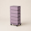 Purple drawer unit on wheels with four drawers against a beige background