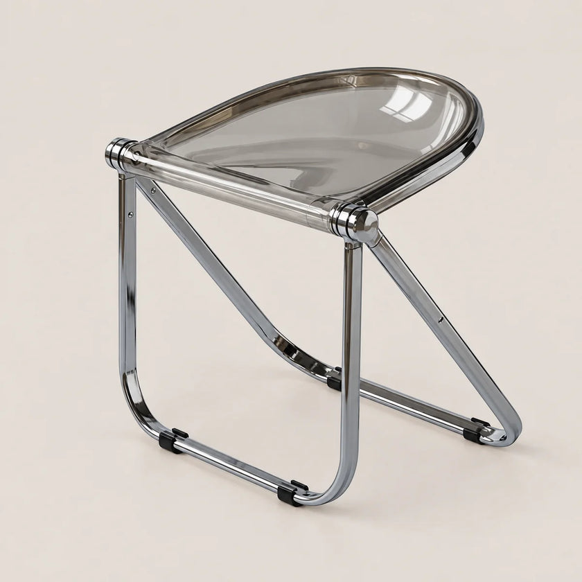 A modern folding stool with a clear smoked-tinted seat and a polished chrome metal frame, shown on a solid light beige background.