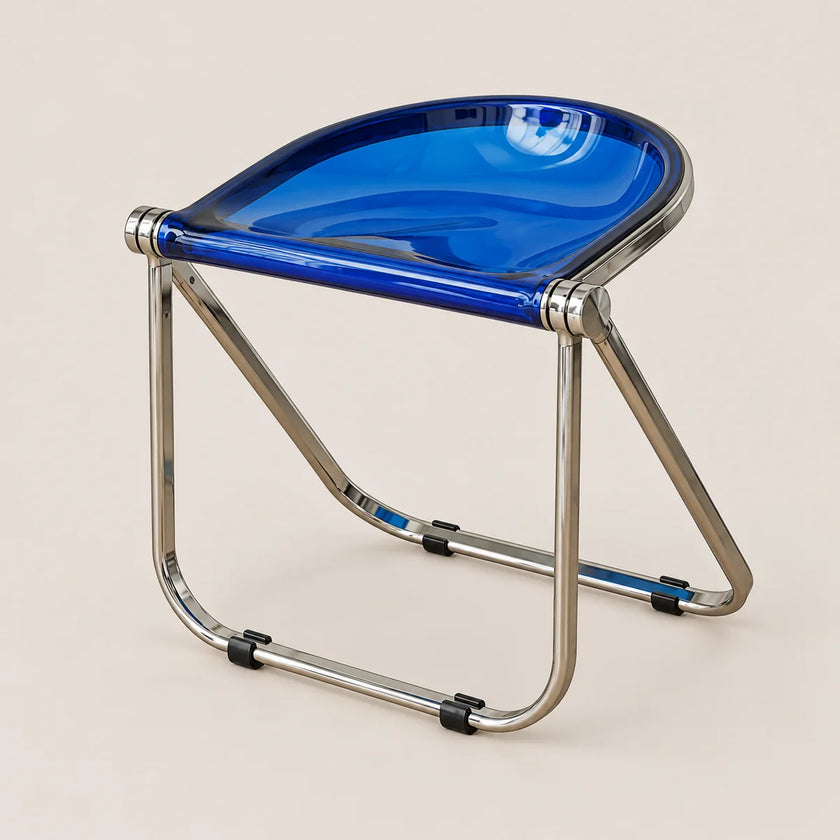 A modern folding stool with a glossy translucent blue seat and a polished silver metal frame, shown on a solid light beige background.