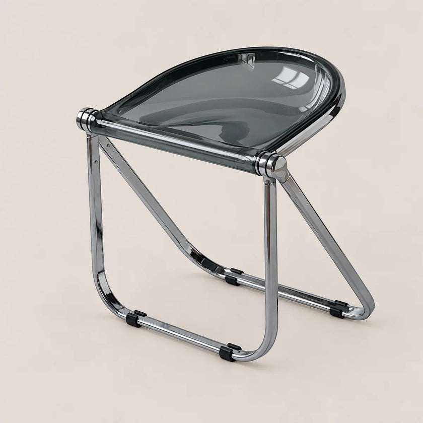 A modern folding stool with a translucent dark gray seat and a polished chrome metal frame, shown on a solid light beige background.