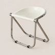 A modern folding chair with a glossy white molded seat and a polished chrome metal frame, shown on a solid light beige background.