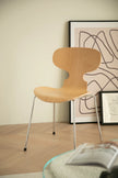 Wooden dining chair in a room with abstract art on the wall