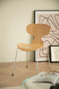 Wooden dining chair in a room with abstract art on the wall
