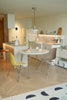 Modern kitchen with a round dining table and chairs on a wooden floor.