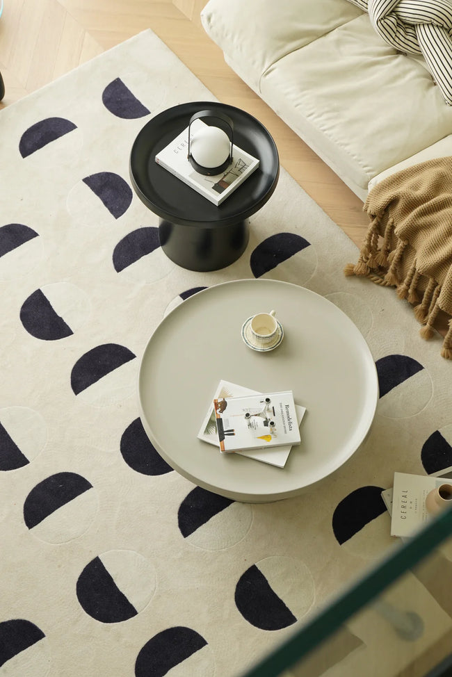 Living room with a patterned rug, coffee table, and decorative items.