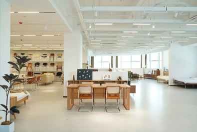Modern office space with wooden desks, chairs, and bookshelves.