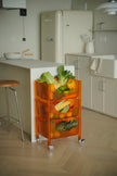Orange plastic containers rolling cart with vegetables in a modern kitchen