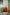 Orange plastic containers 3 tier rolling cart with a plant and books in a living room setting.