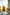 Orange 3 tier rolling cart with decorative items in a living room setting.
