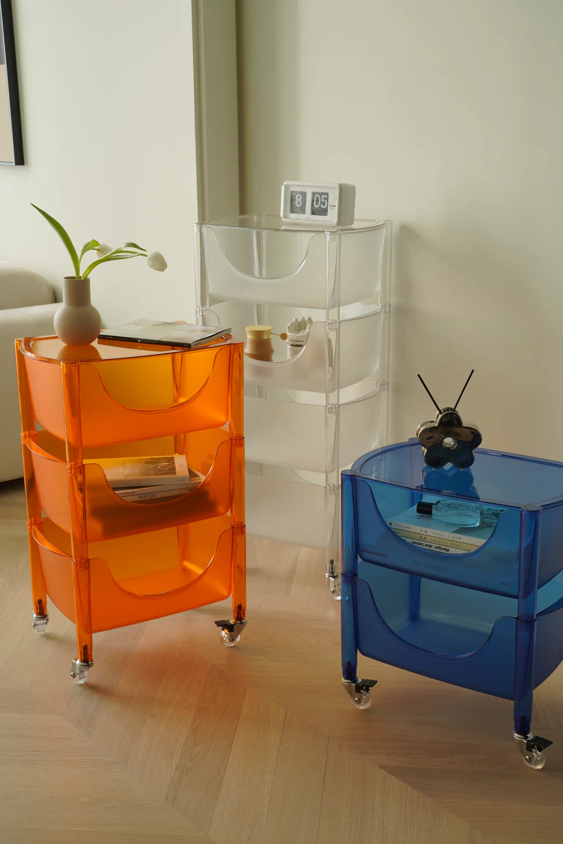 Three colorful plastic containers storage carts in a room setting.