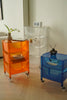 Three colorful plastic containers storage carts in a room setting.