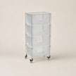 Clear plastic rolling cart with multiple shelves on a beige background