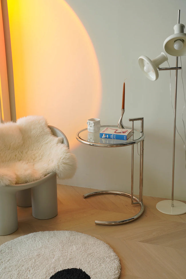 Modern interior with a chair, small round side table, and floor lamp.