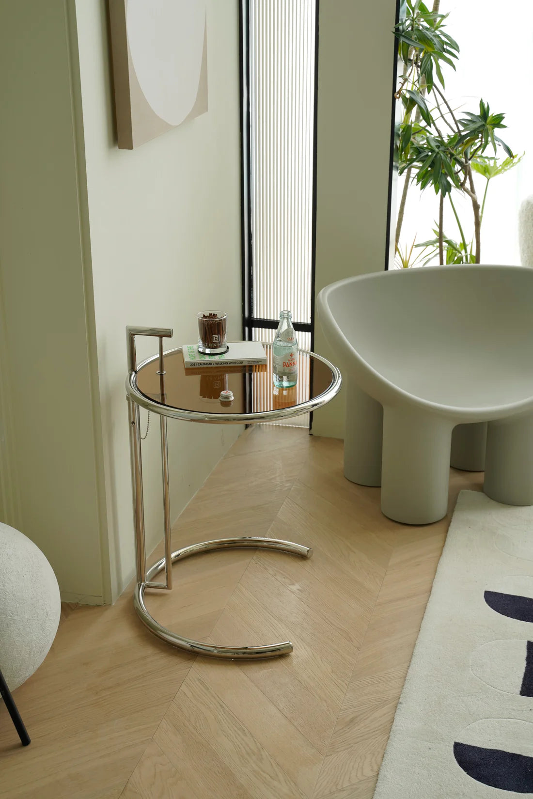 Modern interior with a glass small side table and a white chair.