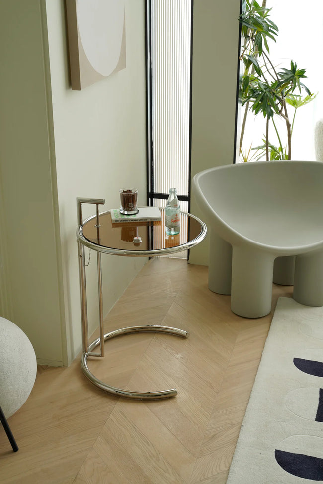 Modern interior with a glass small side table and a white chair.