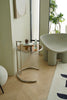 Modern interior with a glass small side table and a white chair.